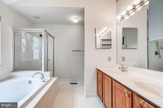 a bathroom with a tub a sink and mirror