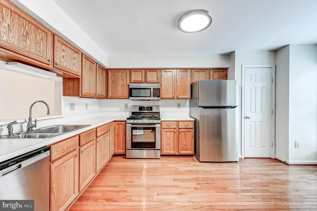 a kitchen with stainless steel appliances granite countertop a refrigerator sink and stove