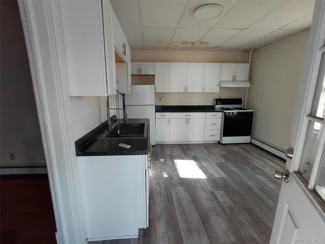 a kitchen with a sink a stove and cabinets