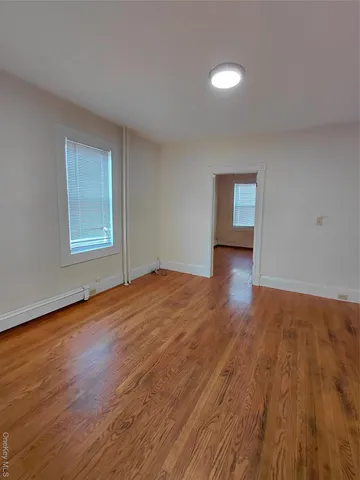 a view of a room with wooden floor and window
