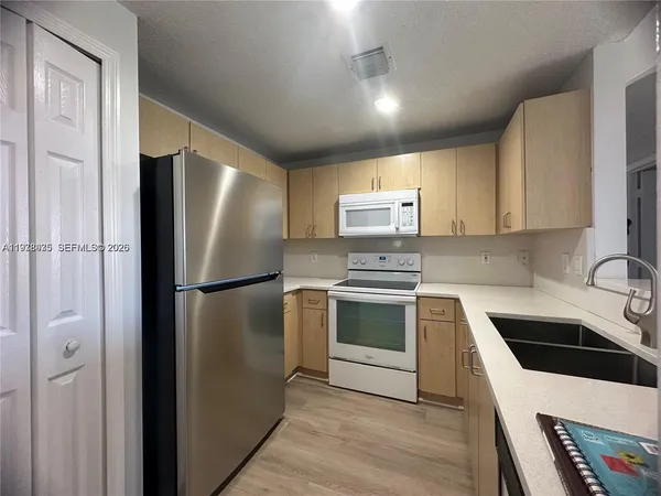 a kitchen with a refrigerator sink and stove