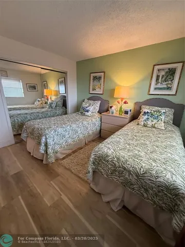 a bedroom with two beds and a lamp on dresser