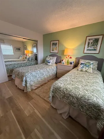 a bedroom with two beds and painting on the wall