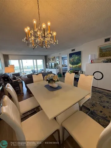 a view of a dining room with furniture and chandelier