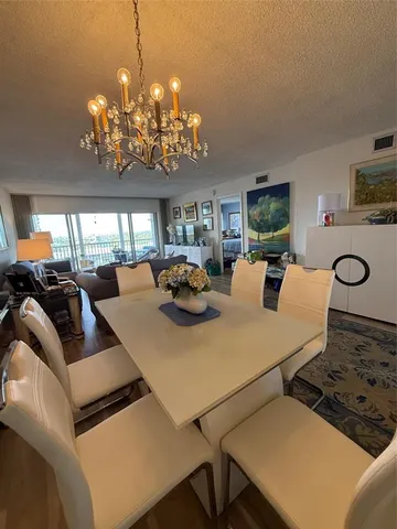 a view of a dining room with furniture and chandelier