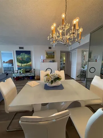 a view of a dining room with furniture and a chandelier