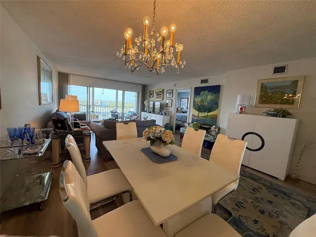 a very nice looking dining room with furniture a chandelier and window