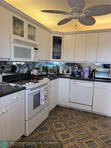 a kitchen with a stove a sink and cabinets