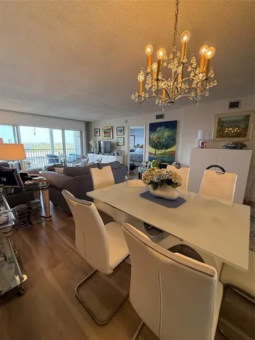 a living room with furniture a chandelier and a dining table