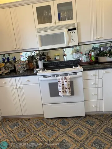 a white stove top oven sitting inside of a kitchen