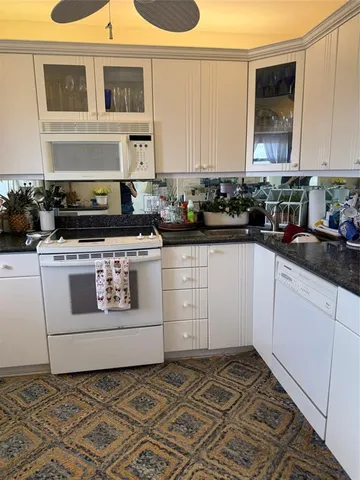 a kitchen with a stove and white cabinets