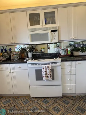 a white stove top oven sitting inside of a kitchen