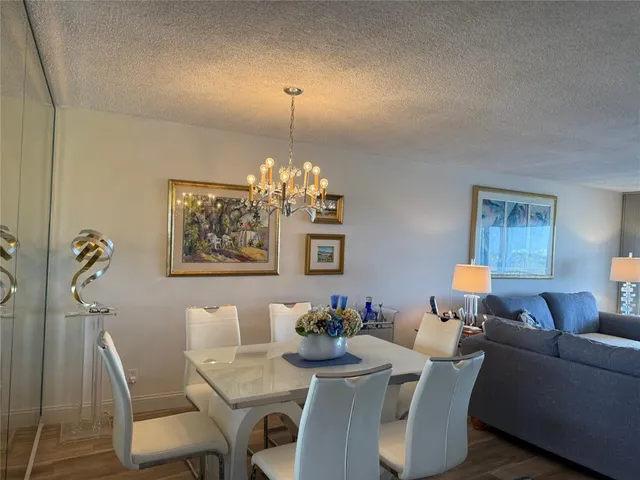 a view of a dining room with furniture and chandelier
