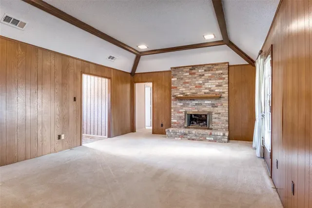 a view of an empty room with a fireplace and a window