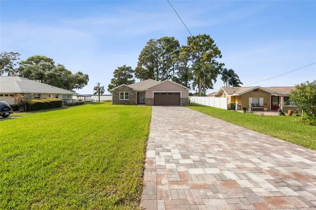 a front view of a house with yard and green space