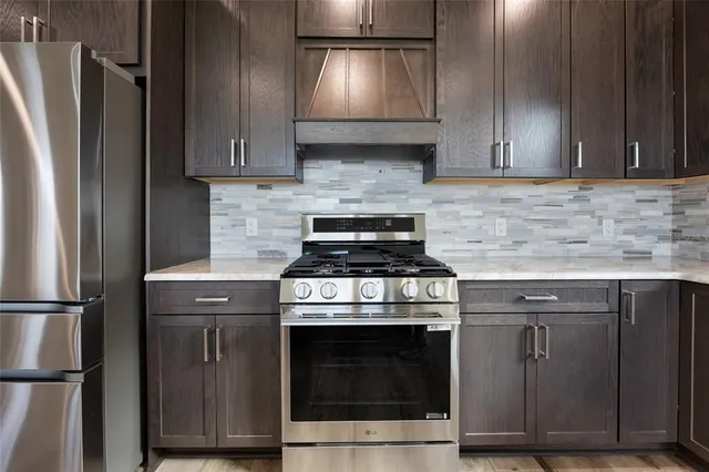 a kitchen with granite countertop wooden cabinets and stainless steel appliances