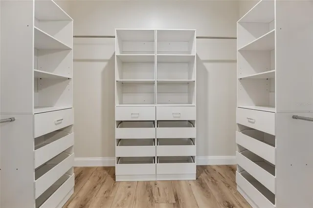 a view of walk in closet with empty racks