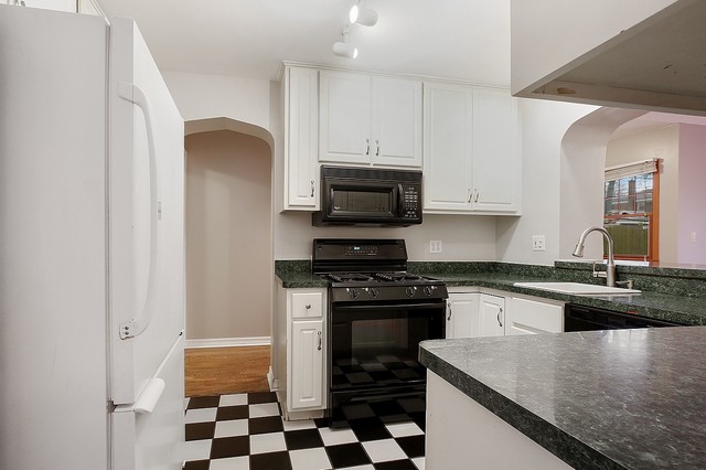 18427 Stewart Avenue Homewood, IL 60430 - Photo 5 of 13 a kitchen with granite countertop a sink and a stove top oven with wooden floor