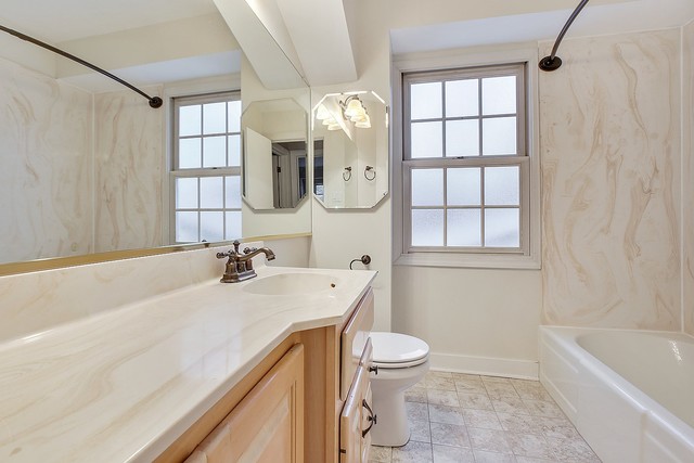 18427 Stewart Avenue Homewood, IL 60430 - Photo 8 of 13 a bathroom with a granite countertop sink a toilet and bathtub