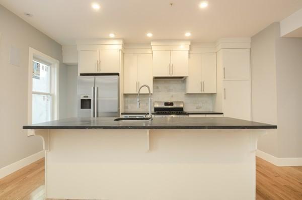 339 West Broadway, Unit 2 Boston, MA 02127 - Photo 1 of 7 a kitchen with stainless steel appliances granite countertop a sink a stove and a refrigerator