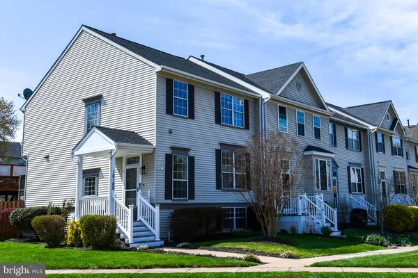 a front view of a house with a yard and potted plants
