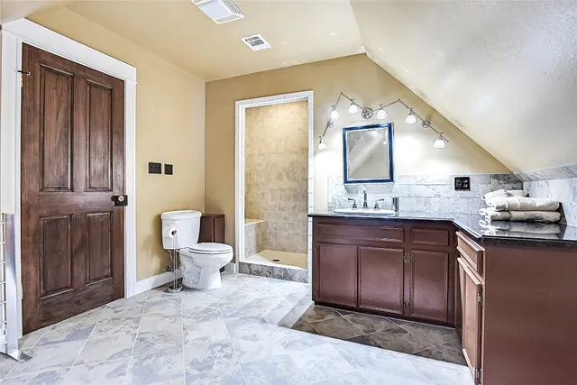 a spacious bathroom with a granite countertop sink toilet and shower