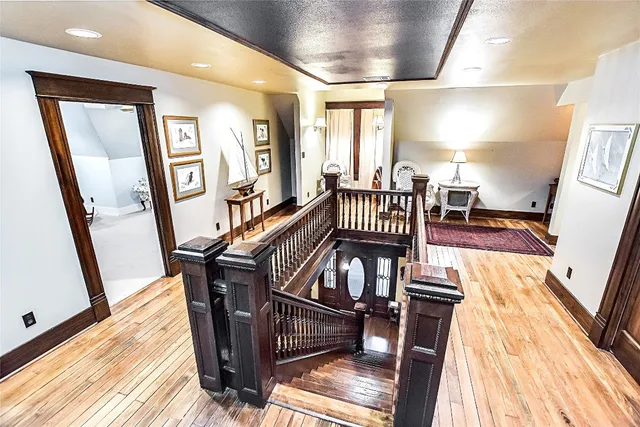 a view of a hallway with wooden floor and staircase
