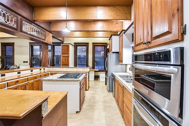 a kitchen with stainless steel appliances granite countertop a sink and stove top oven