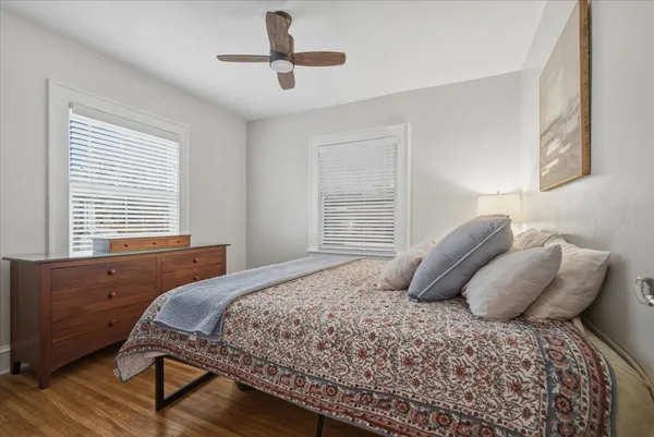 a bedroom with a large bed and two large window
