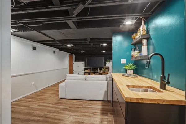a room with a sink and wooden floor