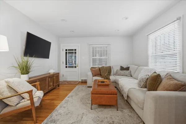 a living room with furniture a flat screen tv and a large window