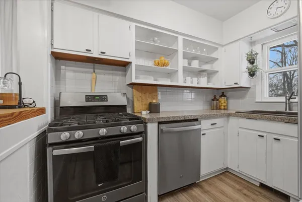 a kitchen with granite countertop cabinets stainless steel appliances and wooden floor