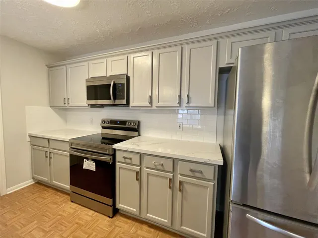 a kitchen with stainless steel appliances granite countertop a refrigerator stove and microwave