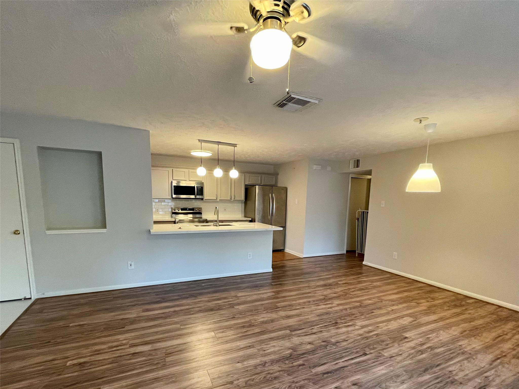8051 Bay Branch Drive, Unit 312 The Woodlands, TX 77382 - Photo 14 of 22 a view of a kitchen with wooden floor and a ceiling fan