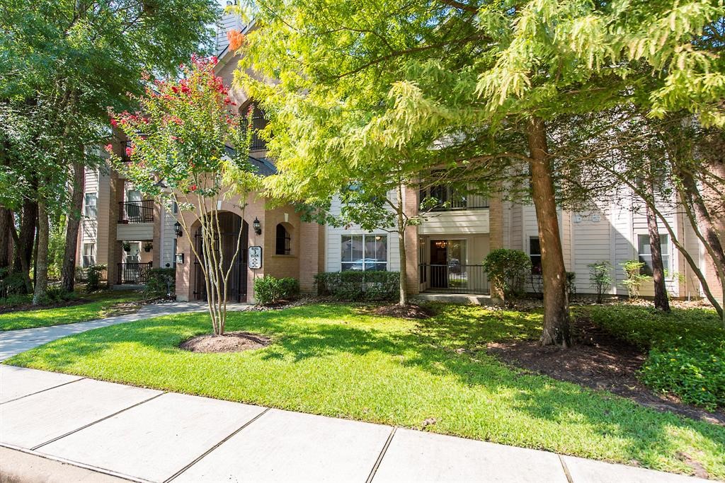 8051 Bay Branch Drive, Unit 312 The Woodlands, TX 77382 - Photo 21 of 22 a backyard of a house with yard and outdoor seating
