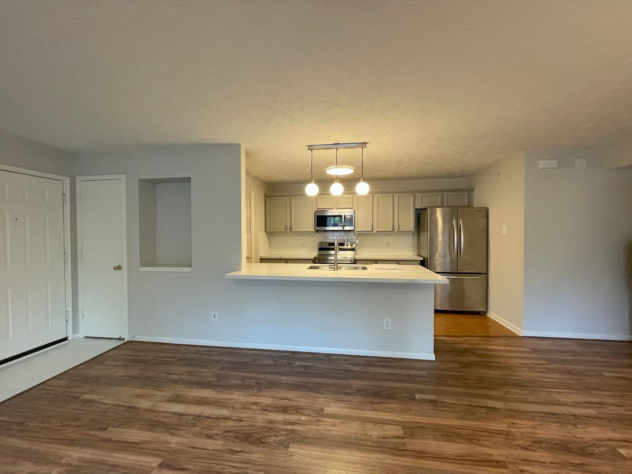 8051 Bay Branch Drive, Unit 312 The Woodlands, TX 77382 - Photo 6 of 22 a view of kitchen and hallway with wooden floor