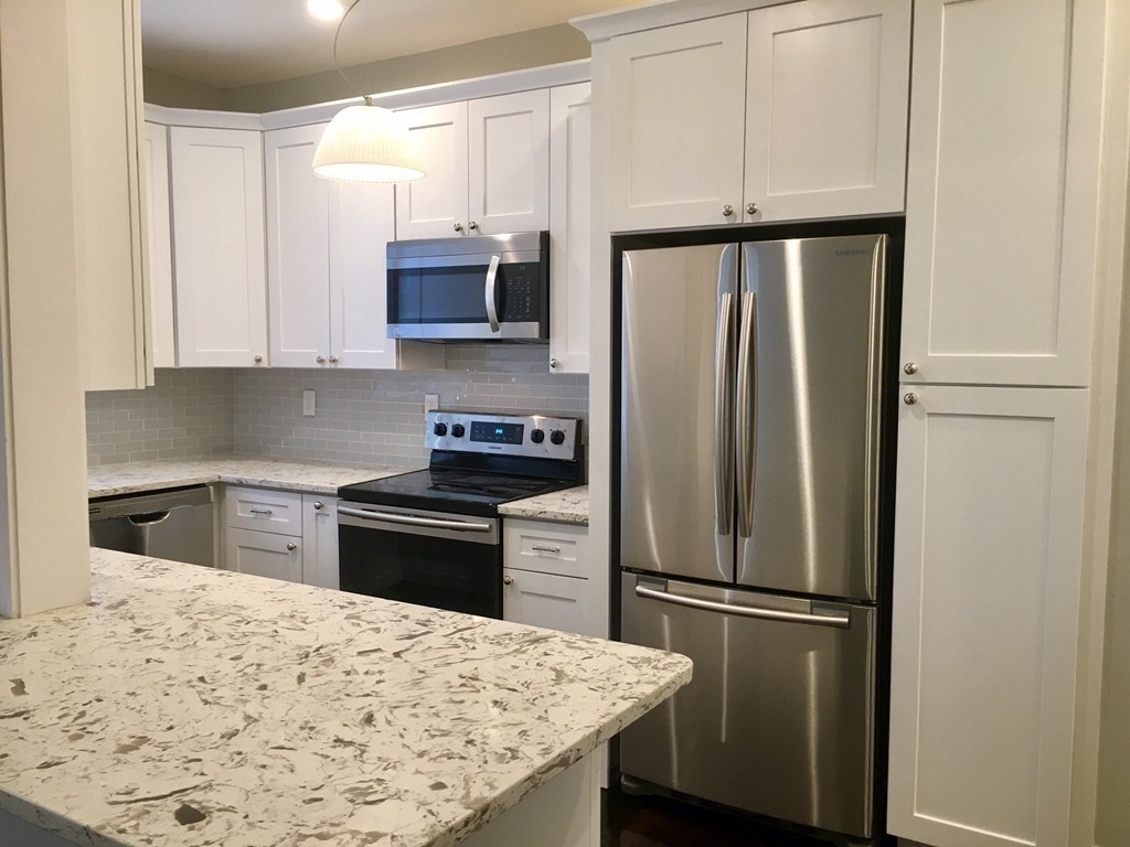 a kitchen with a refrigerator and a stove top oven