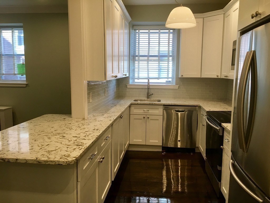 1834 Beacon Street, Unit 3 Brookline, MA 02445 - Photo 2 of 7 a kitchen with stainless steel appliances granite countertop a sink stove and refrigerator