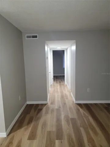 an empty room with wooden floor and closet
