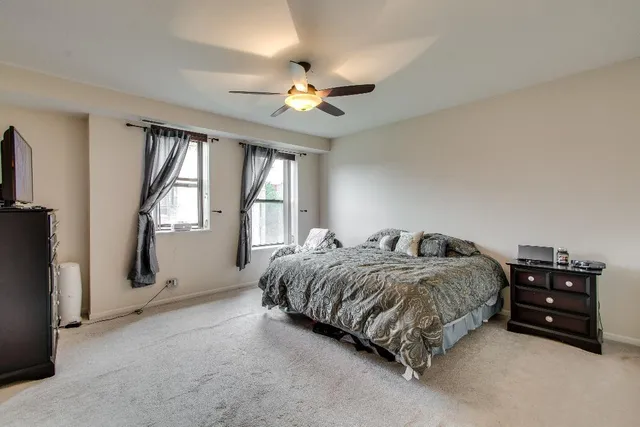 a spacious bedroom with a bed and a chandelier