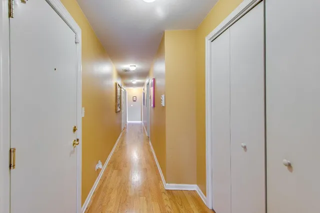 a view of a hallway with wooden floor
