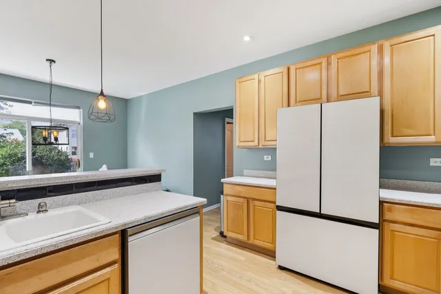 a kitchen with a refrigerator a sink and cabinets