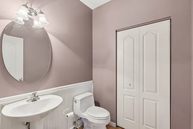 a bathroom with a toilet a sink and mirror