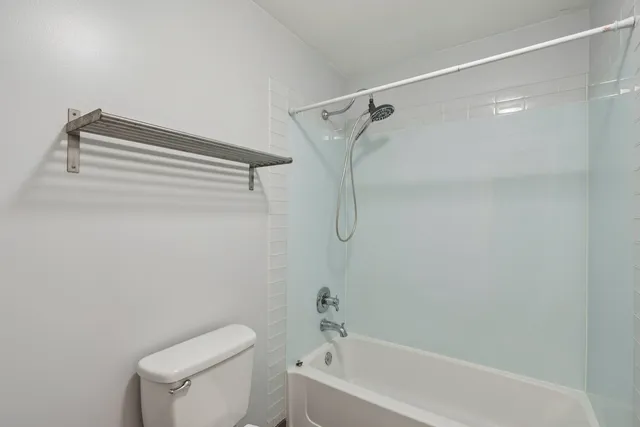 a white toilet sitting next to a bath tub