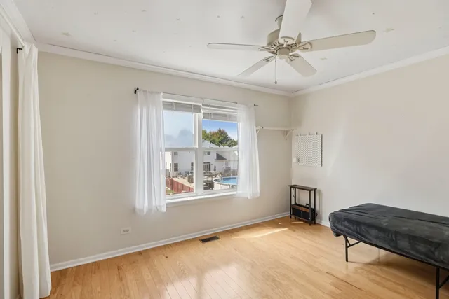 a view of an empty room with a window and a dresser