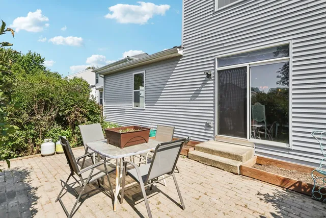 a backyard of a house with table and chairs