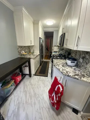 a kitchen with kitchen island granite countertop wooden cabinets and stove