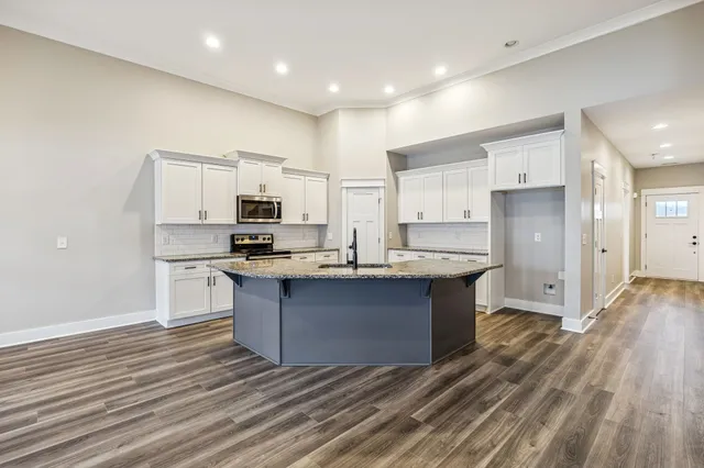 a kitchen with stainless steel appliances granite countertop a stove and a refrigerator