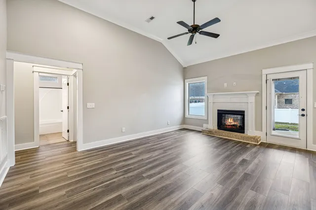 wooden floor fireplace and windows in an empty room