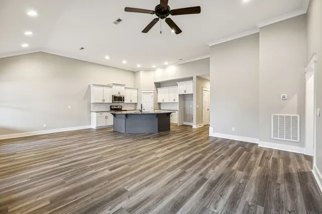 a view of empty room with wooden floor and ceiling fan